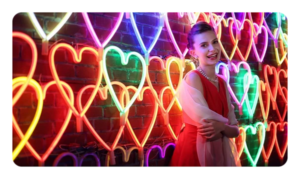 a woman stood in front of wall of light up hearts taken with the canon rf 50mm