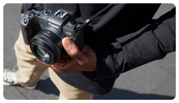 someone holding a camera with the canon rf 50mm attached