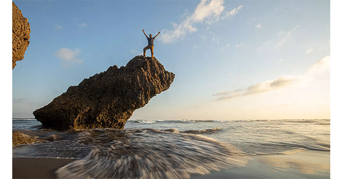 sample image of a man on  cliff surrounded by the ocean taken with the canon 35mm lens