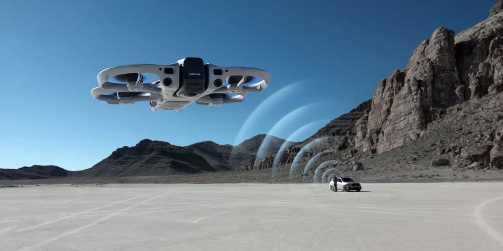 dji avata 360 with someone flying it lent against a car in the background