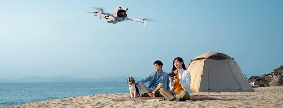 a family flying the dji lito 1 while camping on a beach