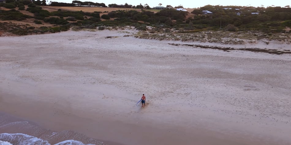 top down view of a surfer on a beach