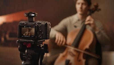 dji mic 3 mounted to a camera being used to record a musician
