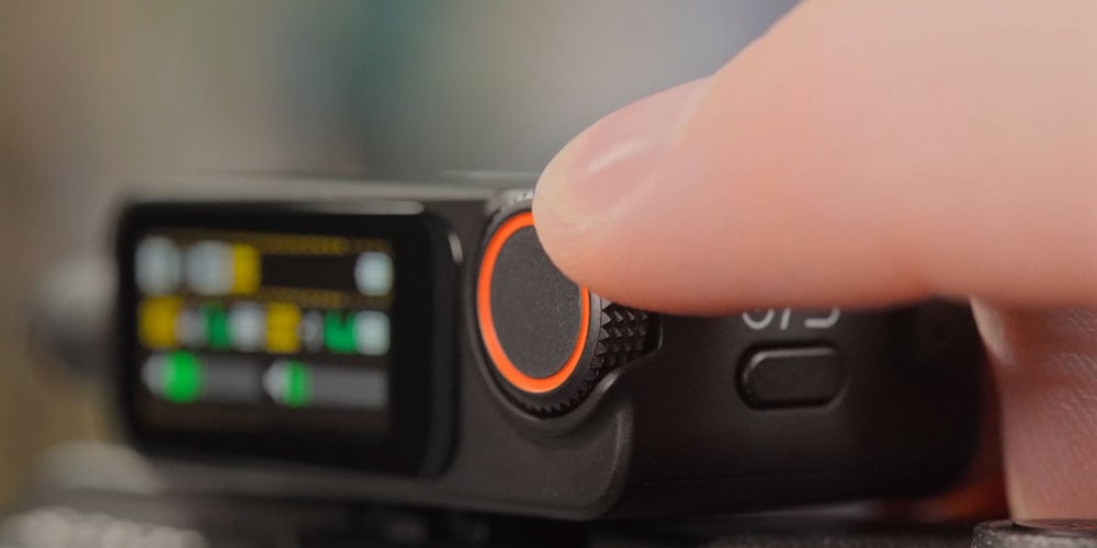 someone making adjustments on the dji mic 3 receiever
