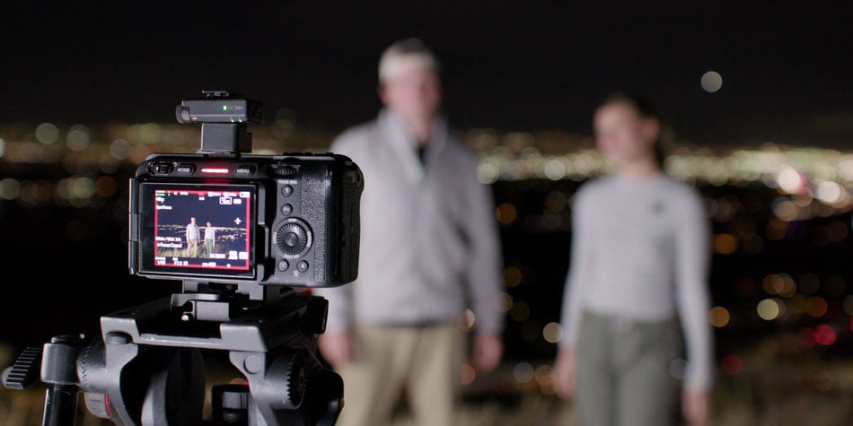 behind the camera view of two people being filmed using the dji mic mini 2