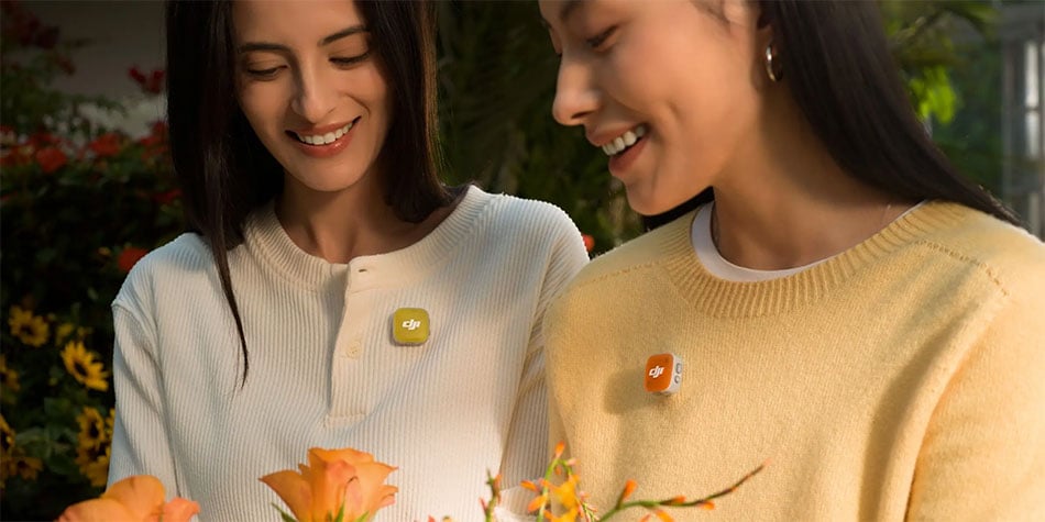 close up of two women wearing the dji mic mini 2 with yellow and orange covers