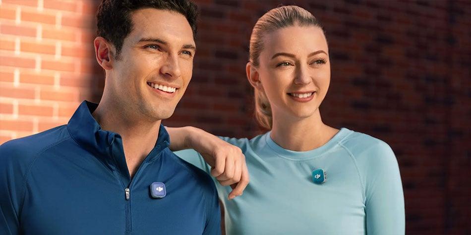 two people looking into the camers wearing sportswear and the dji mic mini 2 with blue covers