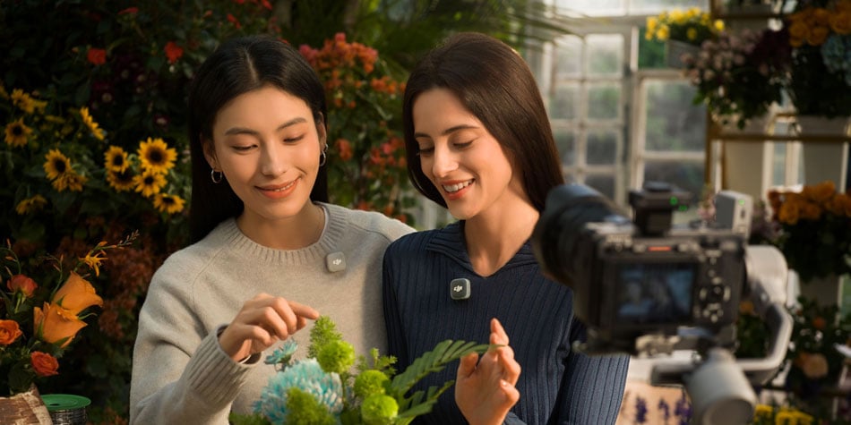 two woman using the dji mic mini while being filmed with plants