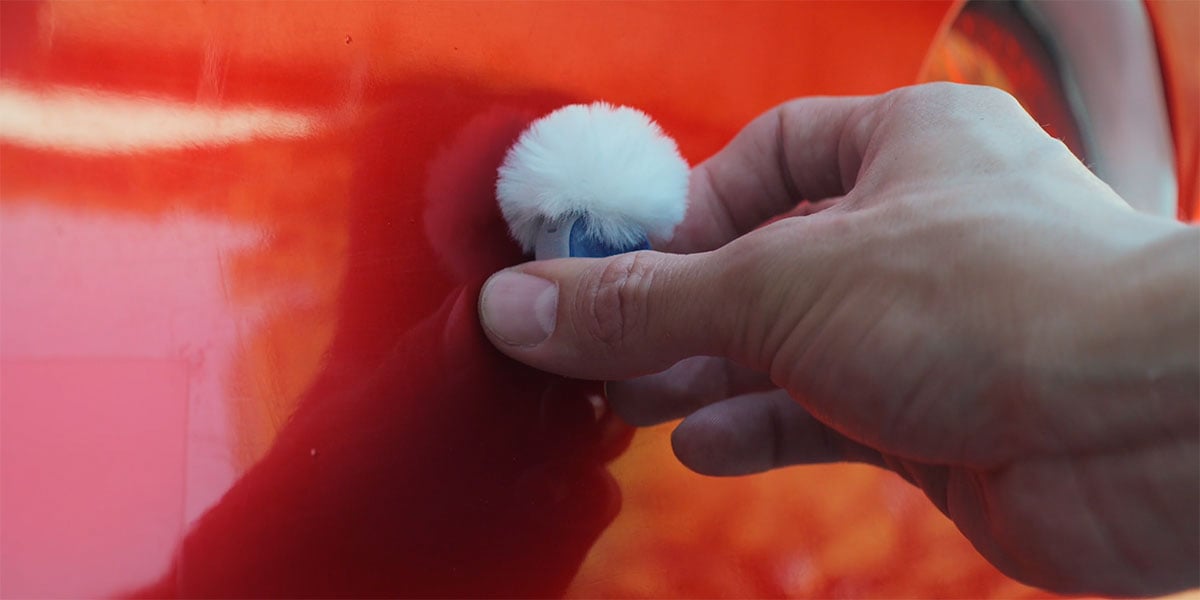 dji mic mini 2s being attached to the side of a red car