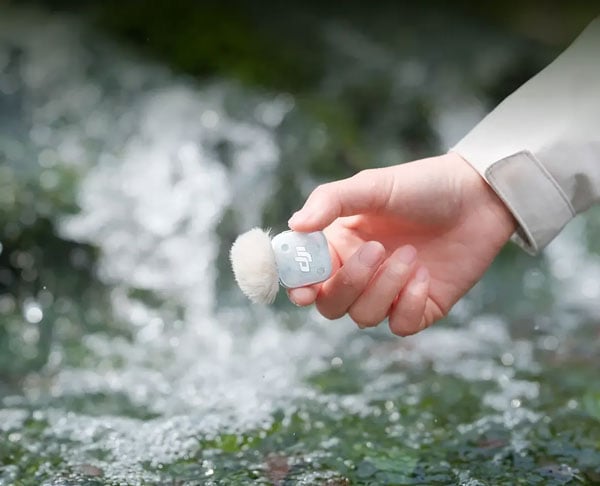 a close up of someone holding the dji mini 2s