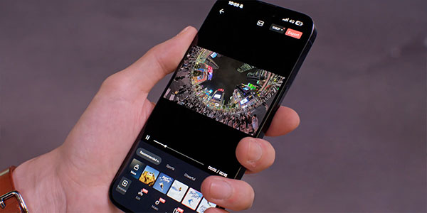 A hand holding a smartphone in the middle of editing footage from the DJI OSmo 360 II