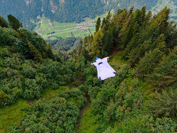 someone using the dji osmo action 6 while gliding in a wing suit