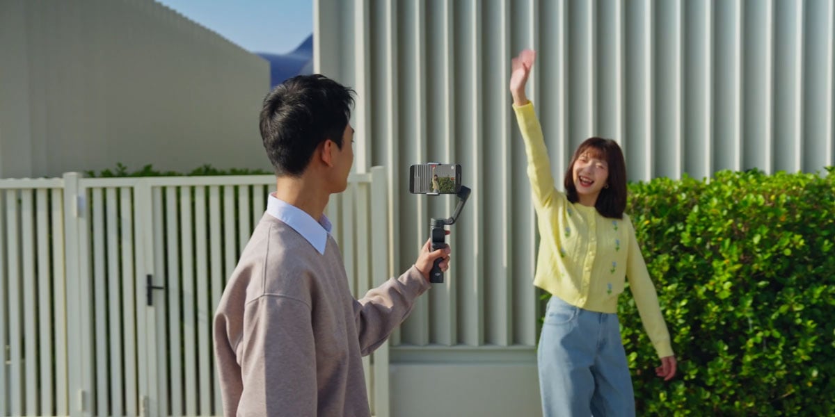 a man filming a waving woman using the fpv mode of the osmo mobile 8p