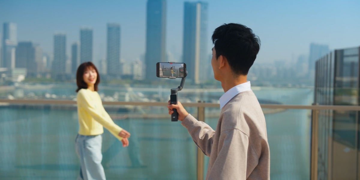 a man filming a woamn on a balcony using the pf mode of the osmo mobile 8p