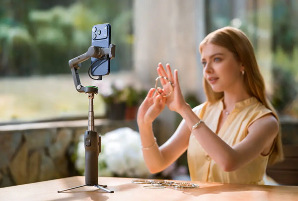 a woman using the osmo mobile 8p on a table while selling jewellery