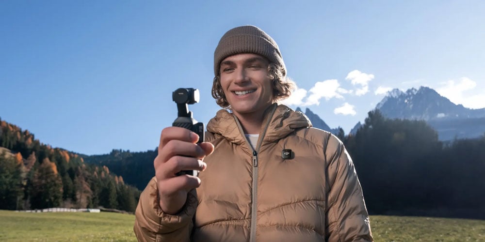 somoen taking a selfie infront of a montain range using the dji osmo pocket 4