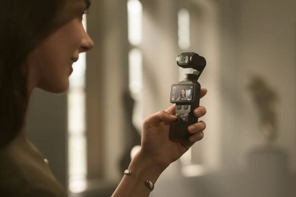 a woamn holding the dji osmo pocket 4 with the camera pointing at her