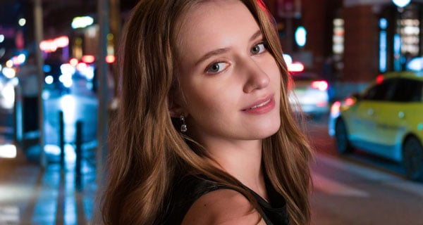 portrait of a woman on a city street at night