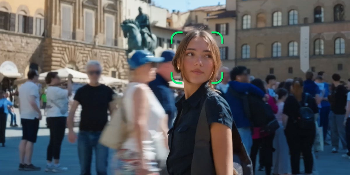 a woman in the mjiddle of a busy crowd being tracked while walking