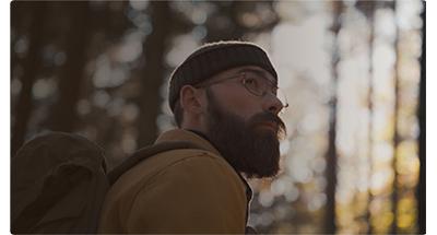 Close up photograph of hipster styled man, hiker, in a forest with the background out of focus, DZOFILM CATTA Lenses