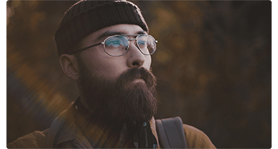 Close up photograph of hipster styled man, hiker, in a forest with the background out of focus, DZOFILM CATTA Lenses