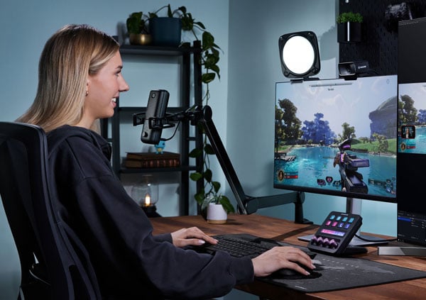 a woman sat at a desk streaming a shooting game using the keylight neo