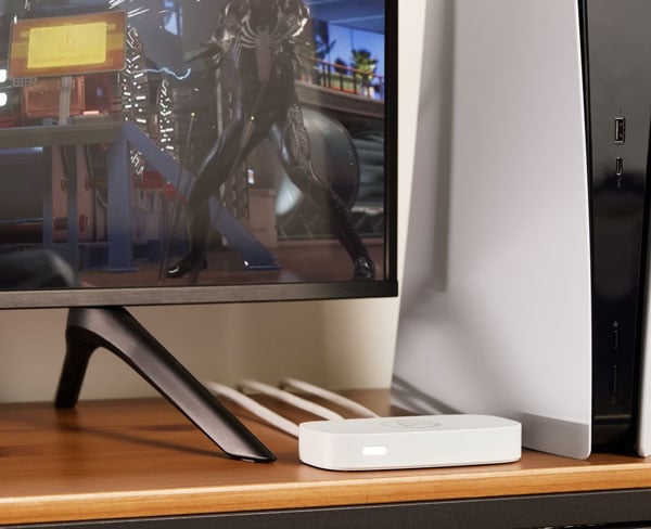 Elgato Game Capture neo external capture card resting on a desk next to a playstation 5