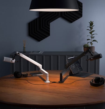 black and white elgato mic arms on a desk