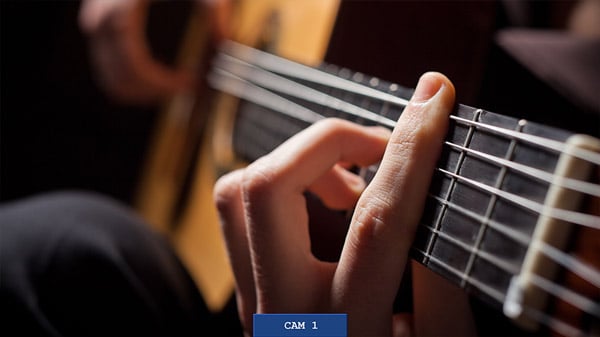 a close-up of a person's hands playing an acoustic guitar with camera display overlay