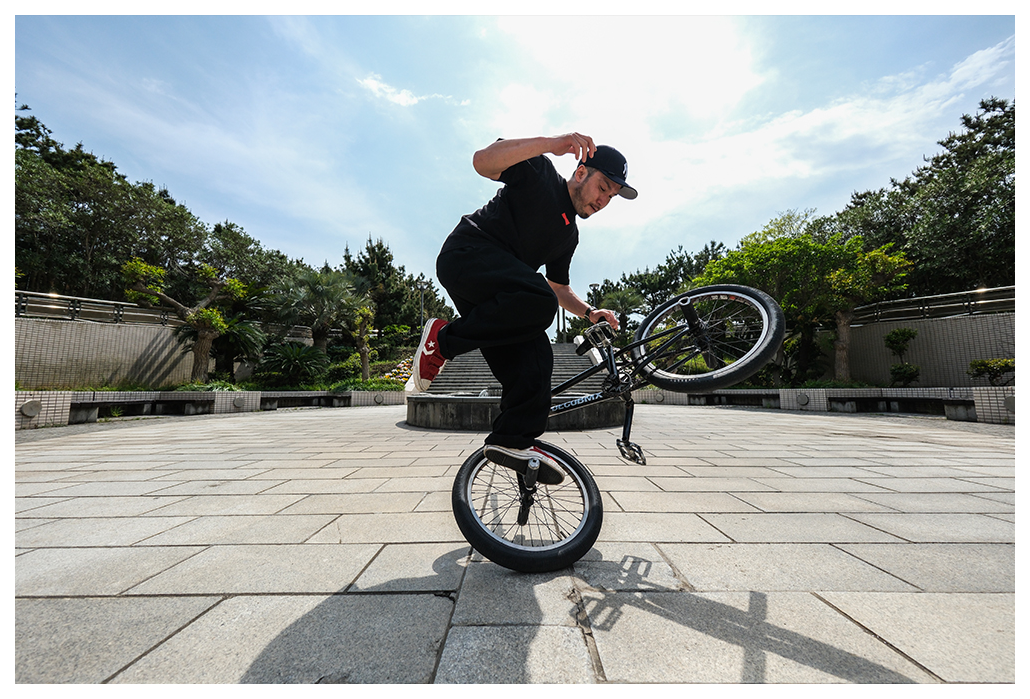 Fujifilm XF8mm F3.5 R WR sample image of freestyle bmw rider doing tricks on flat concrete courtyard