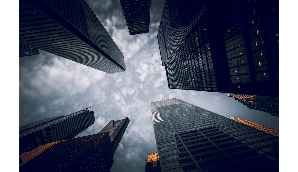 Fujifilm XF8mm F3.5 R WR Sample image skyward view of tall skyscrapers against a grey cloudy sky