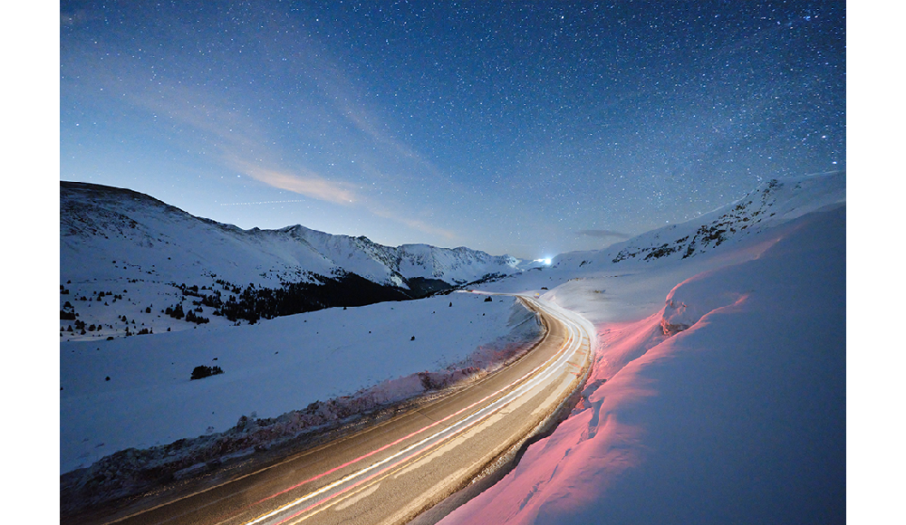 Fujifilm XF8mm F3.5 R WR sample image long exposure of an arctic snowy road with car light trails and clear night sky full of stars
