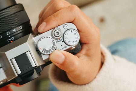 someone using the delector lever on the fujifilm camera