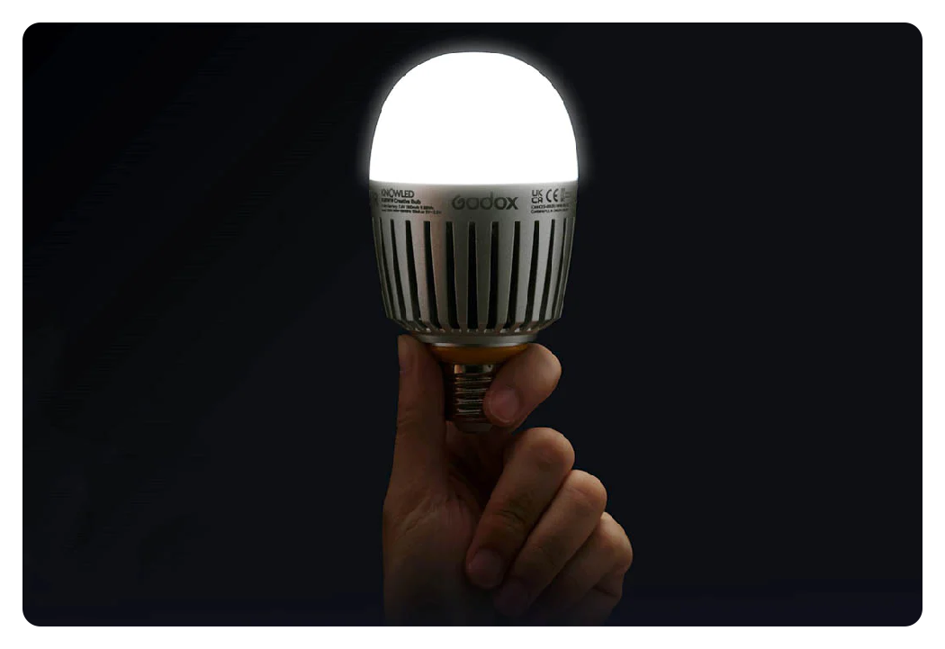 someone holding a powered on godox c7r knowled e27 led bulb