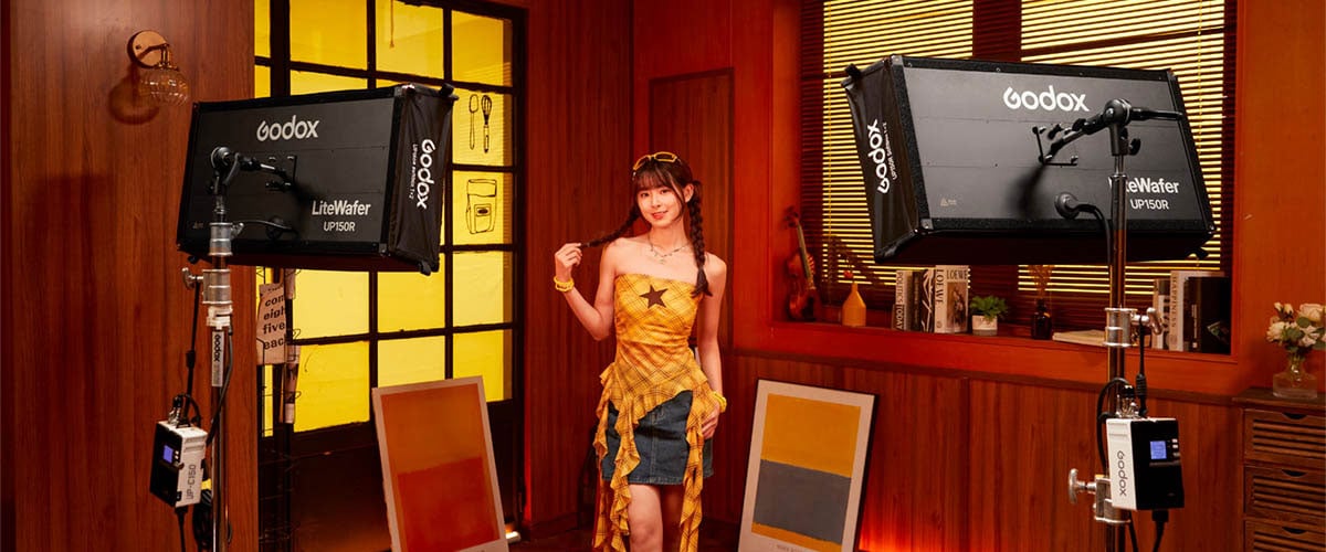 a woman on a red set being lit by two godox lights