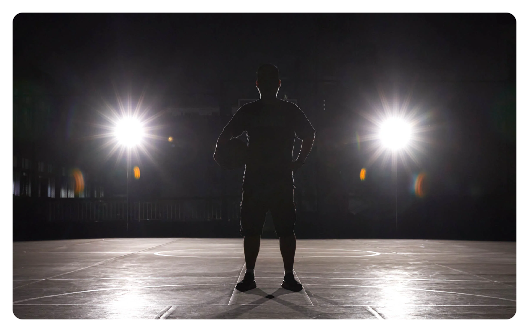 image of a man from behind with a ball under his arm looking into 2 godox led lights