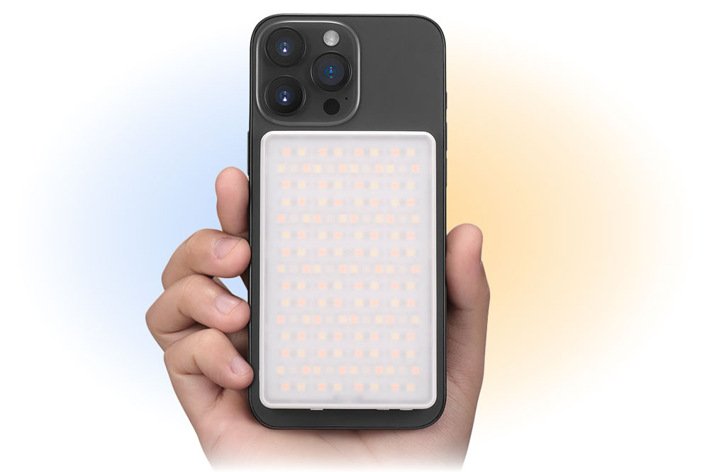 someone holding a smartphone with the godox ma5r attached to the back of it