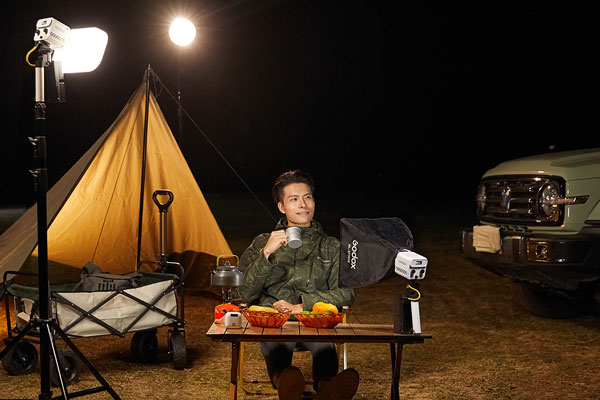 someone sat in front of the godox ml60iibi on a outdoor set