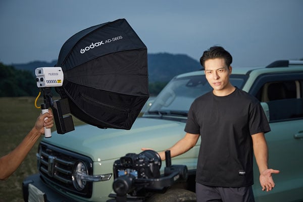 godox ml60iibi being used on set while filming someone in front of a car