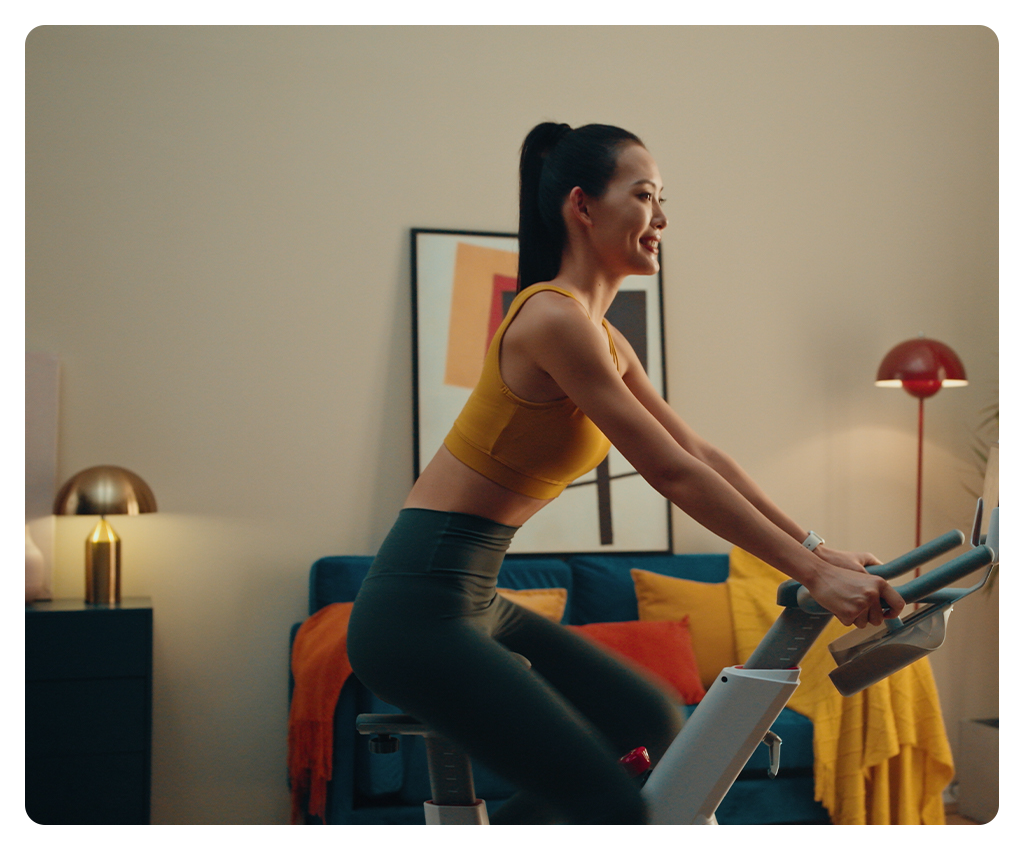 a woman on a exercise bike with the godox p600bi led light shining on her