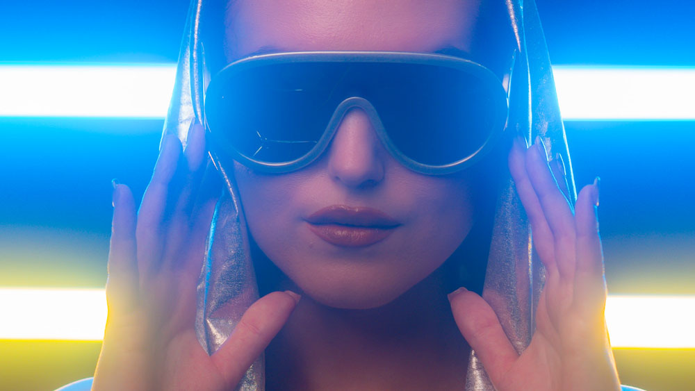portrait of a woman wearing sunglasses with a row of godox tube lights behind her