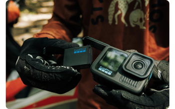 Motocross rider putting battery into GoPro HERO13 Black Action camera