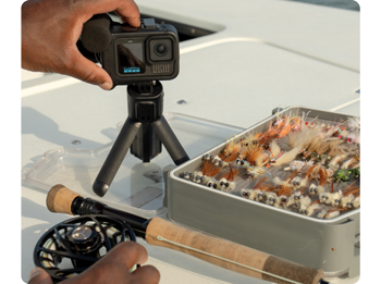 person pressing record on GoPro HERO13 Creator Edition next to fly fishing box
