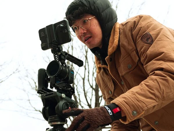 a man in a brown coat recording from behind the gopro mission 1