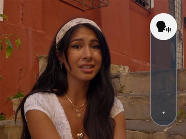 a woman talking in front of a red brick wall with the audio tuning interface