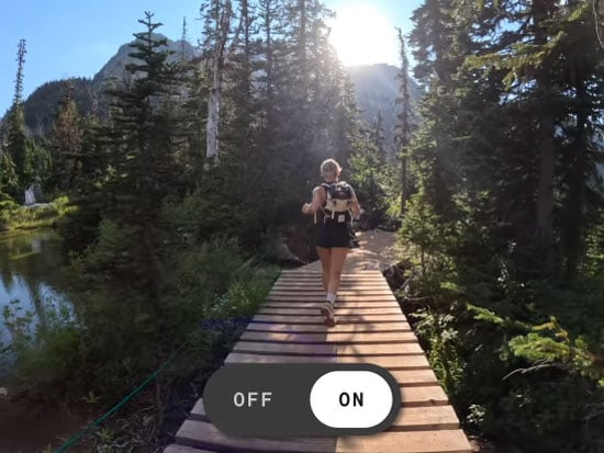screen grab of a woman running across a wooden brige in a wood