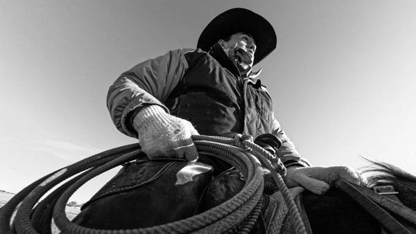 close up in black and white of a cowboy on a horse