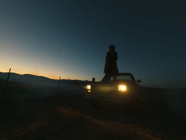 somone stood on a car at night in the desert