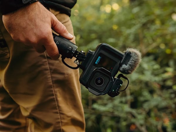someone holding the gopro mission 1 pro attached to the grip handle by their side