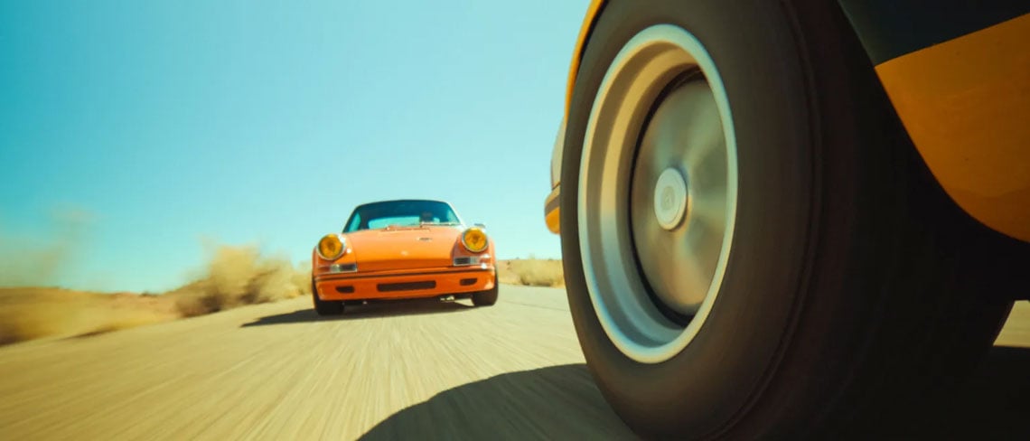 sample image of a car driving down a dirt road taken from the wheel of the car infront